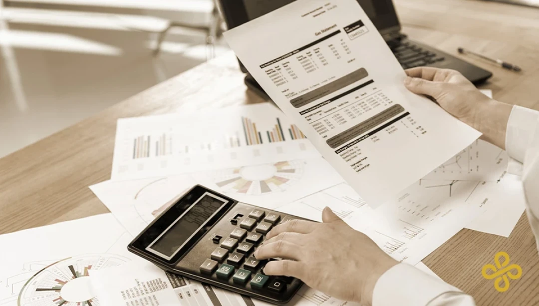 A business person using a calculator and looking at finance documents