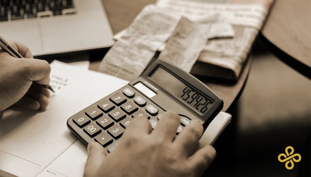 A close-up shot of a hand using a calculator